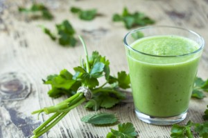 Green smoothie with parsley on wooden table