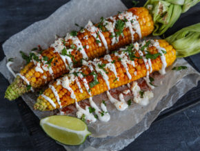 Elote or Mexican grilled corn on the cob served with cotija cheese and chili powder